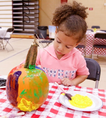 Little girl paints pumkin at RICFest
