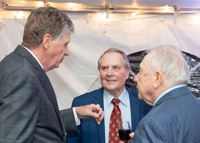 RIC President Jack Warner (center) chats with R.I. Gov. Daniel McKee (right)