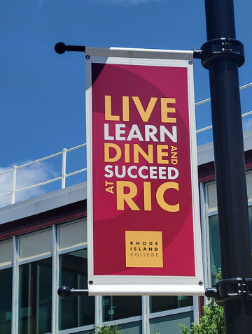 Dining banner, saying Live, Learn, Dine and Succeed at RIC, flying on campus