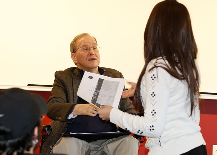 Poli sci student shakes hand of former Congressman Langevin who is visiting their class