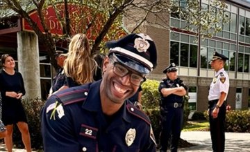 Officer Coleman in foreground with other officers and students talking in background