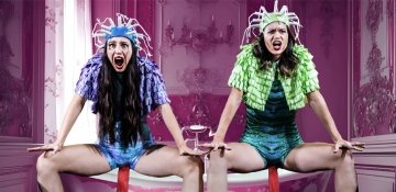 Two female performers sitting with screaming facial expressions