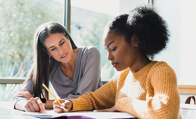 Counselor helping student at table